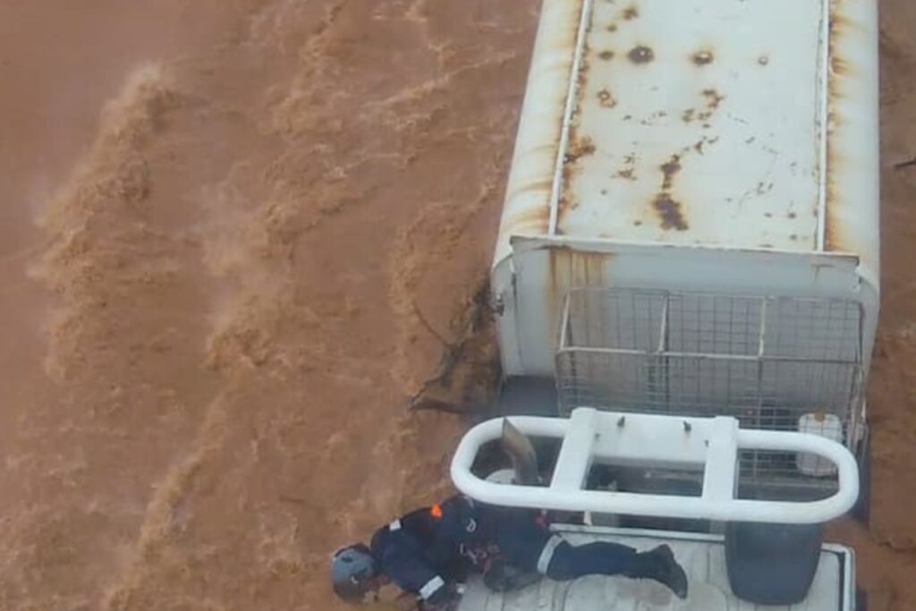 Truckie winched to safety after being trapped in floodwaters